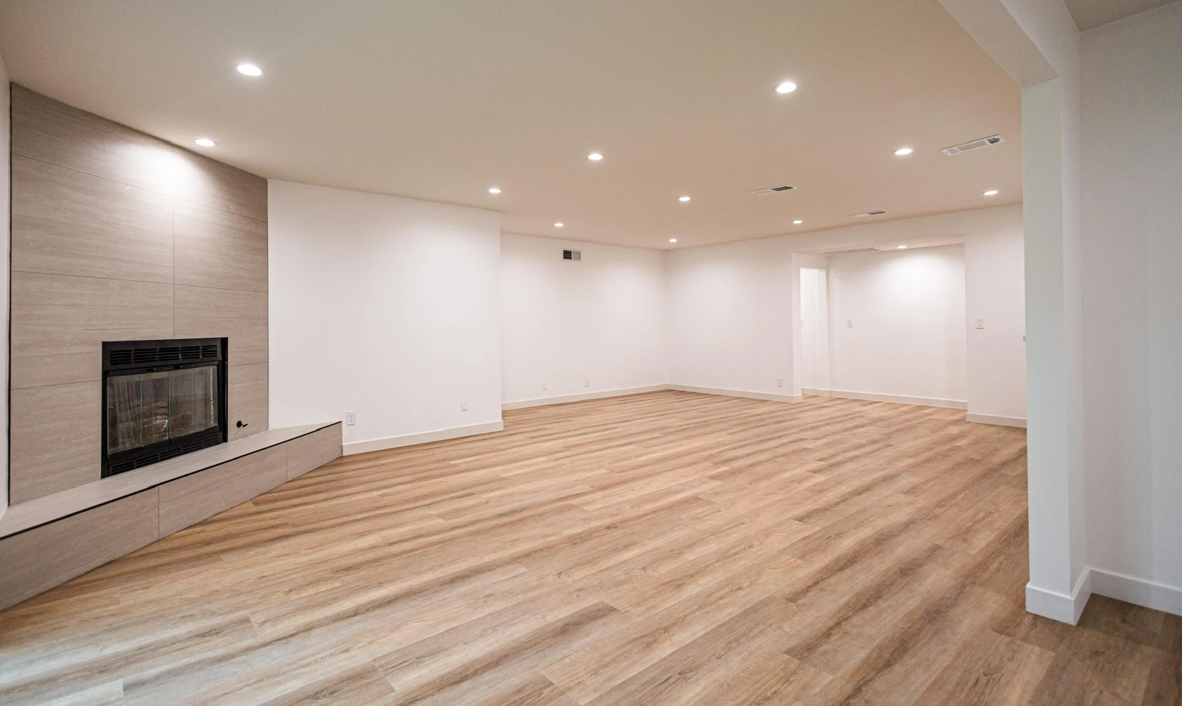 ADU living space with tiled fireplace and wood flooring