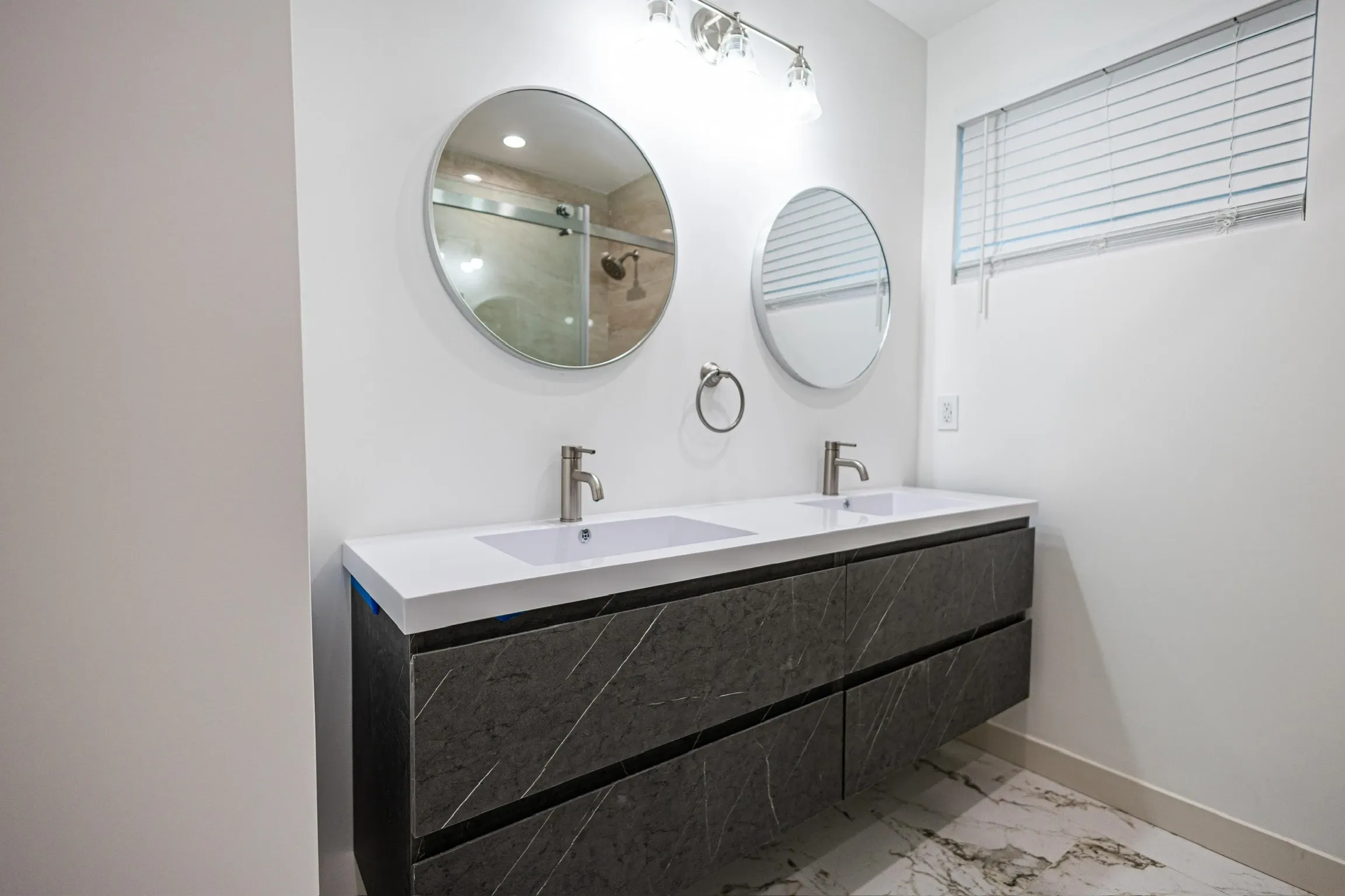 Double vanity with stone front and round mirrors