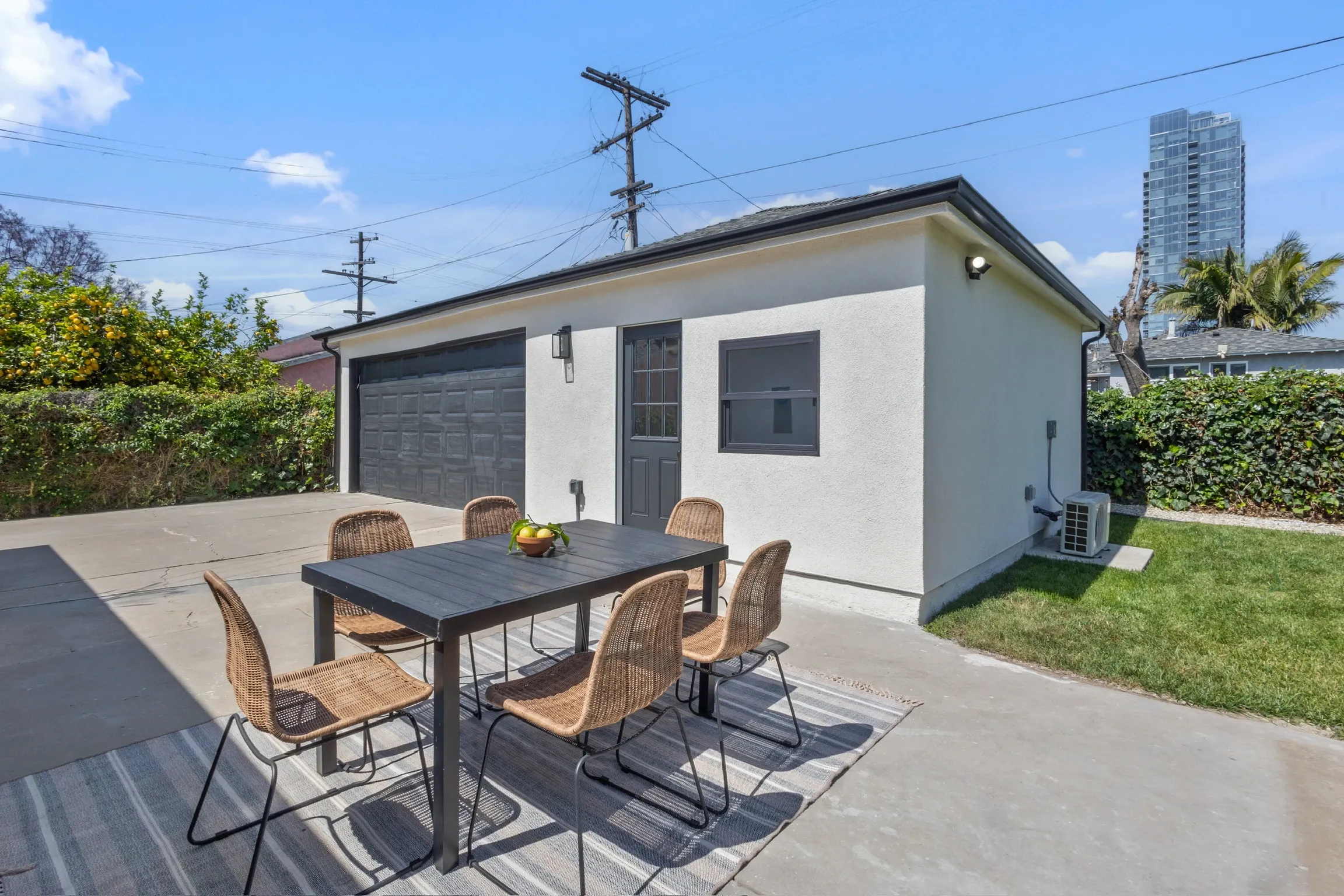 Concrete patio slab with outdoor dining set beside a detached unit