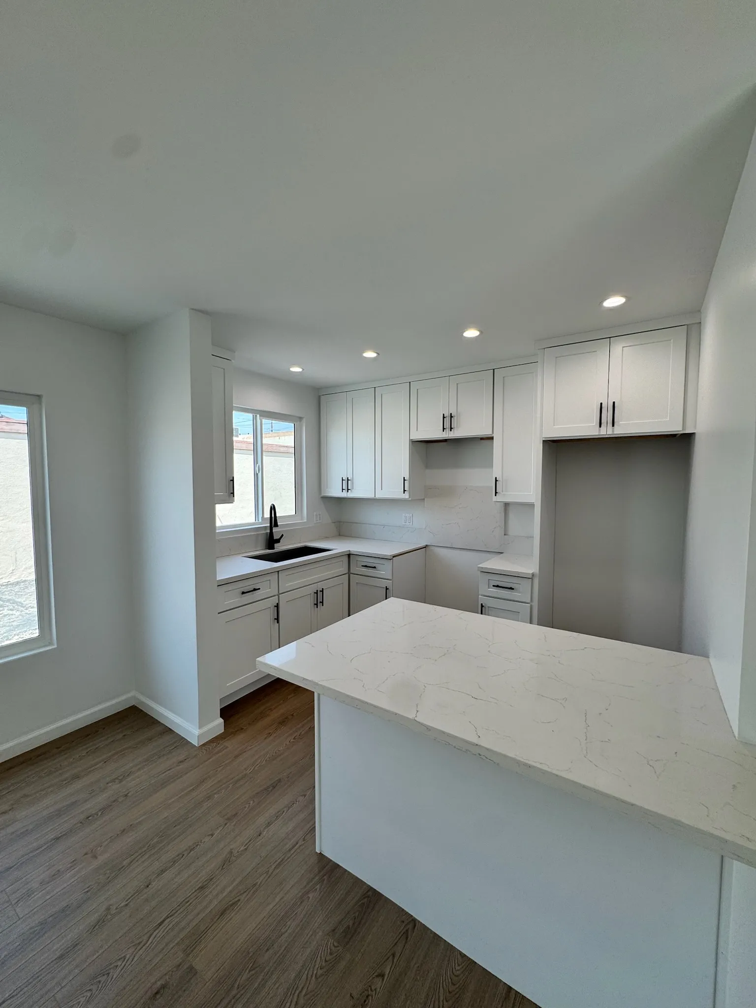 White galley kitchen with quartz peninsula