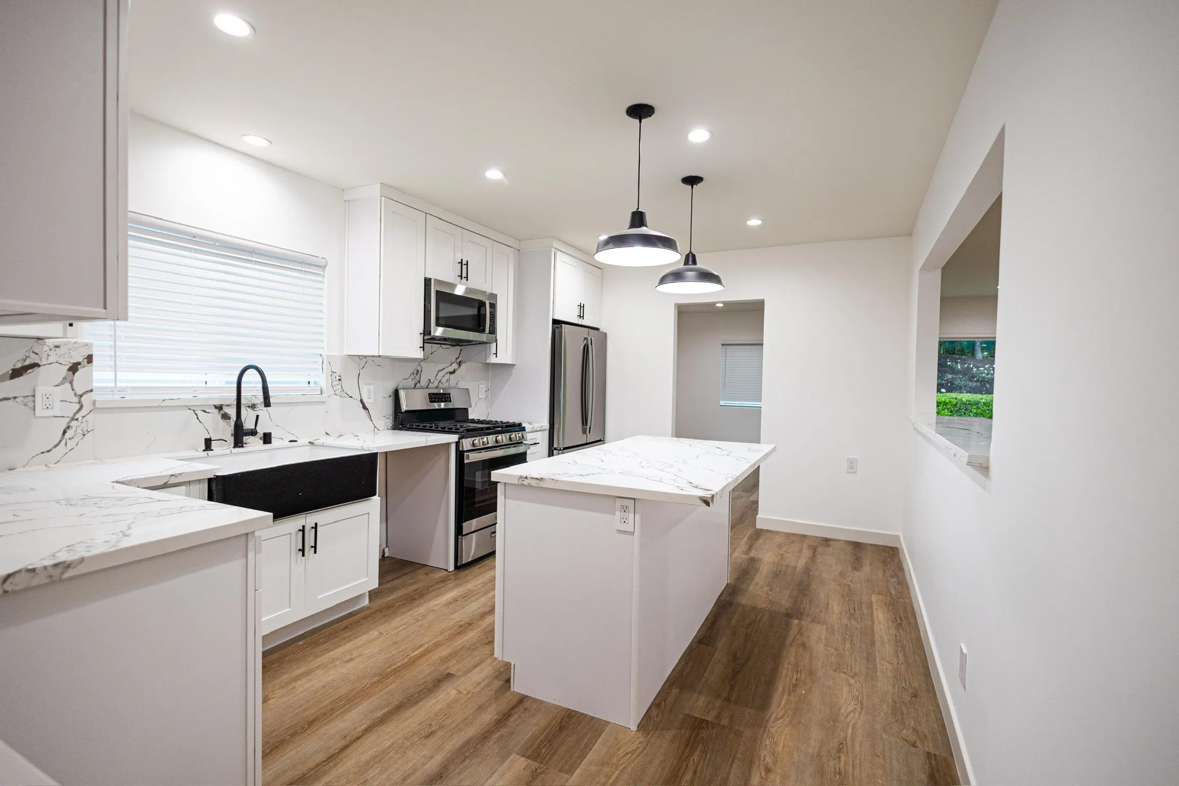Two-tone kitchen with wood-wrapped island and pendant lighting
