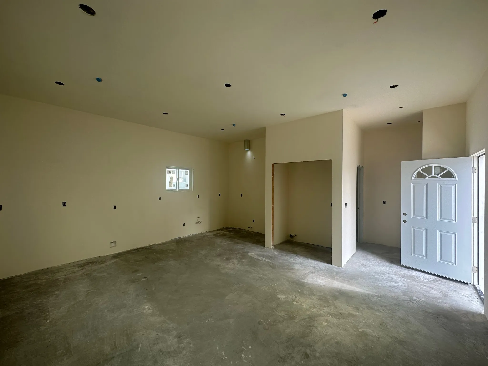 Drywalled interior with entry door during build-out