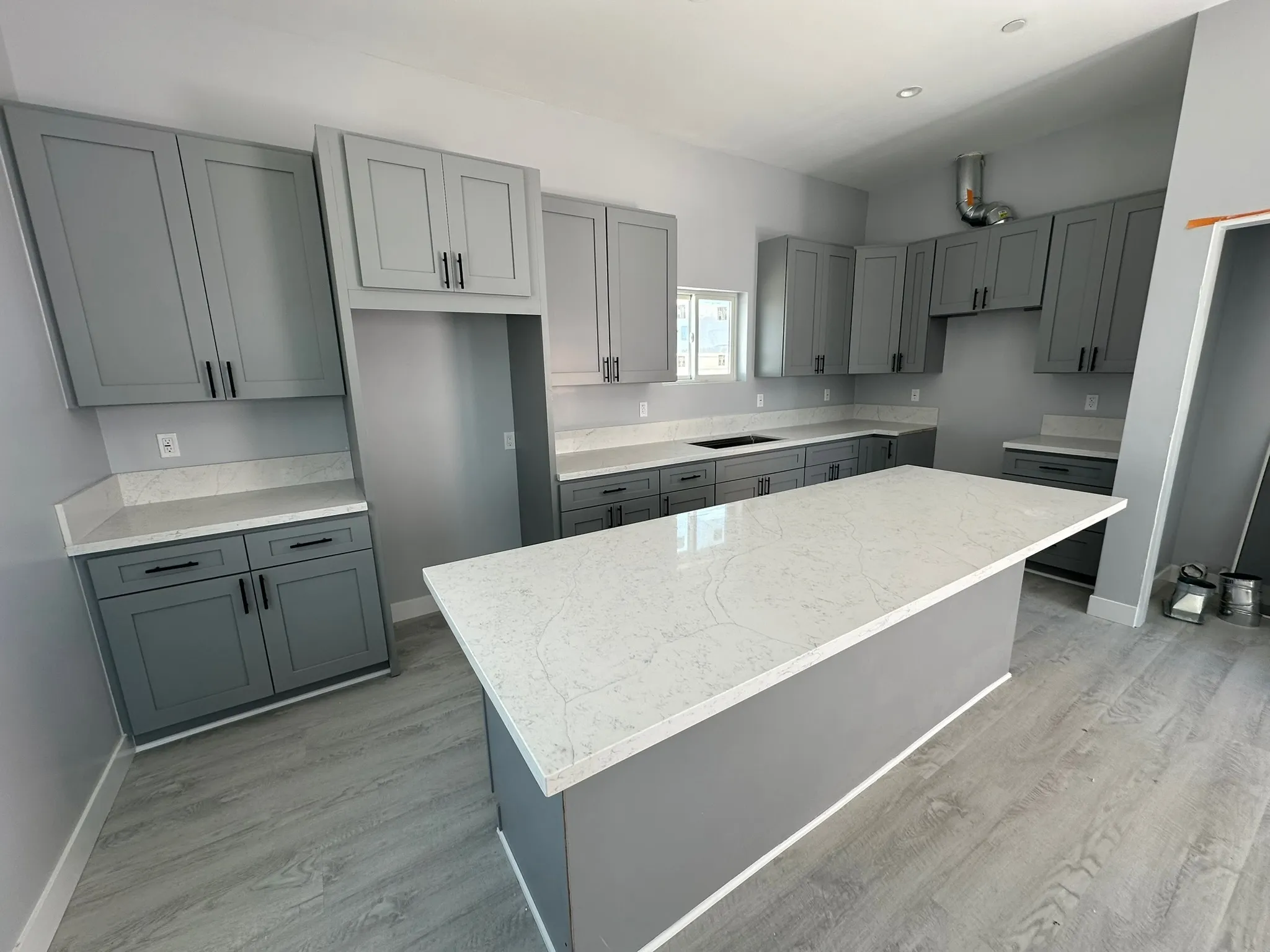 Finished ADU kitchen with quartz island and gray shaker cabinets