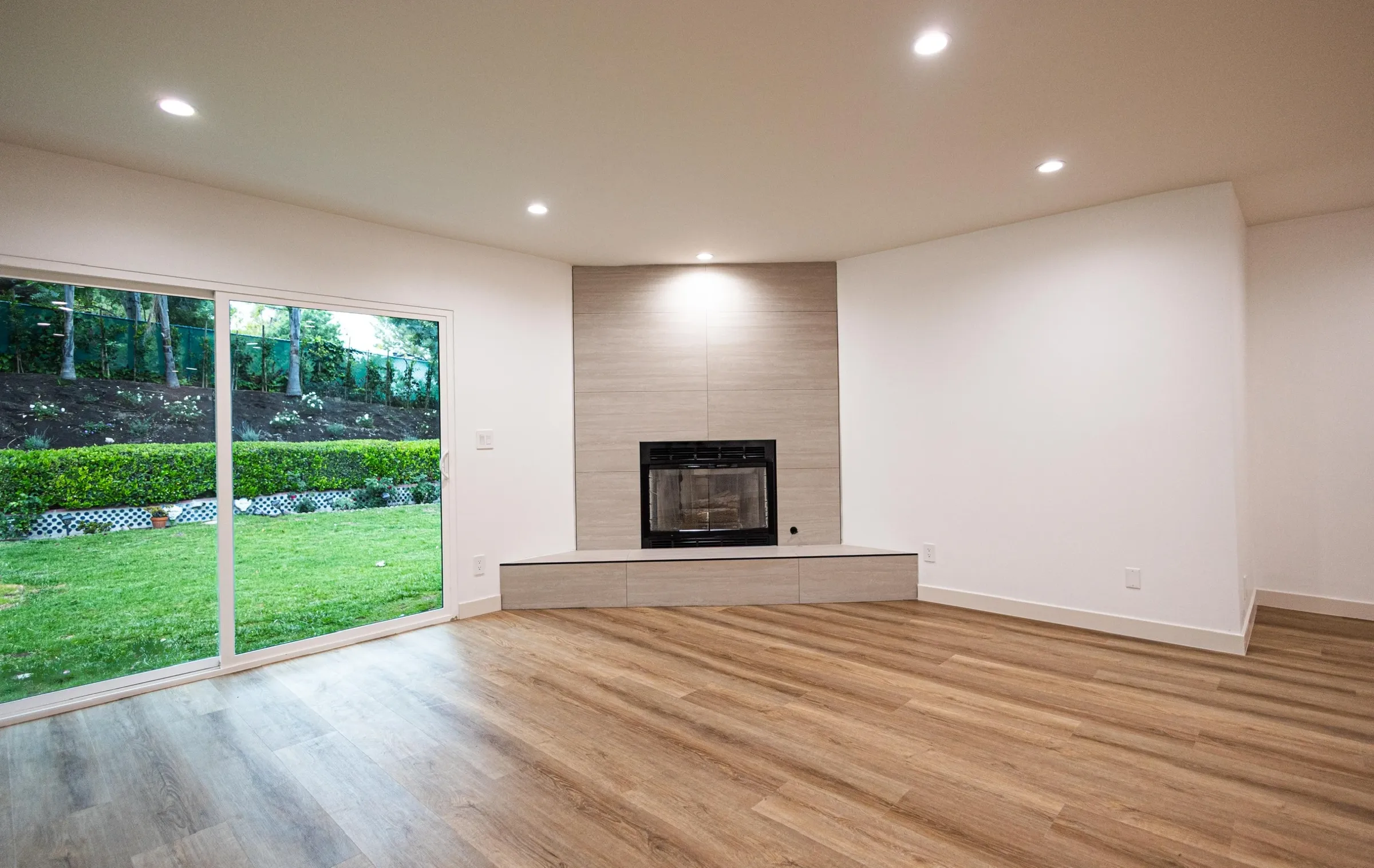 Bright ADU living space with fireplace and sliding doors to the garden